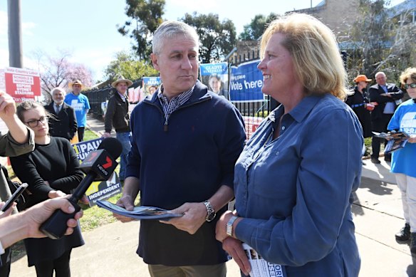 Deputy PM and Nationals leader Michael McCormack hands out how to vote cards with Julia Ham at the Ashmont Primary School voting station.