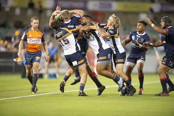 The Brumbies' Tom Banks, Scott Sio, and Joe Powell bundle the Rebels' Angus Cottrell into touch. 