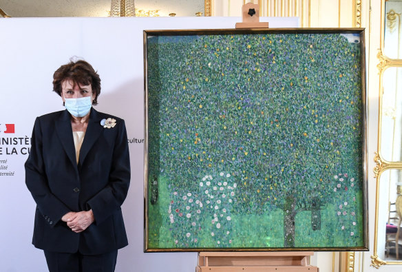 French Culture Roselyne Bachelot poses next to a spoiled oil painting by Gustav Klimt painted between in 1905 called “Rosebushes under the Trees,” during a ceremony at the Orsay museum in Paris. 