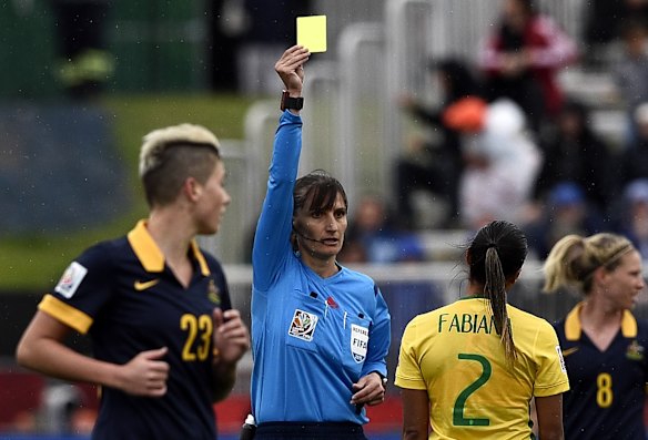 Referee Teodora Albian gives a yellow card to Brazil's defender Fabiana.