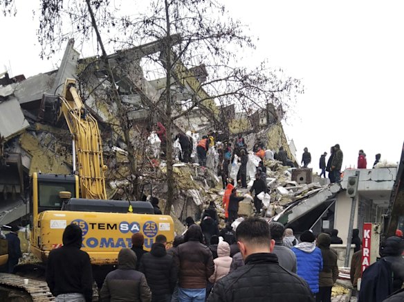 Rescue workers try to reach trapped residents in a collapsed building in Kahta, in Turkey's Adiyaman province.