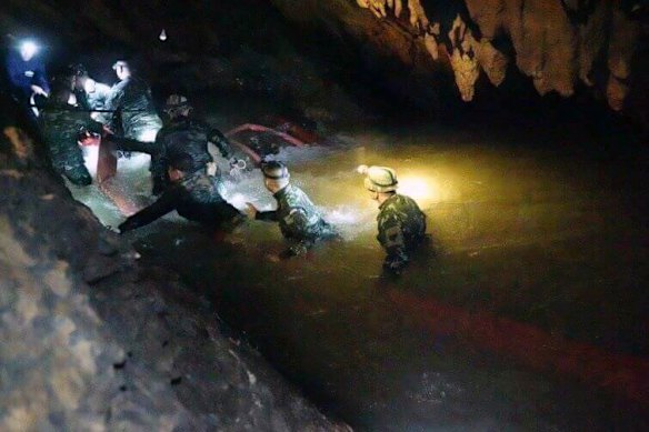 Thai rescue teams walk inside cave complex where 12 boys and their soccer coach went missing, in Mae Sai, Chiang Rai province, in northern Thailand.