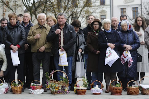 Believers wait for an Orthodox priest to bless traditional Easter cakes and painted eggs prepared for Easter celebrations in Lviv.
