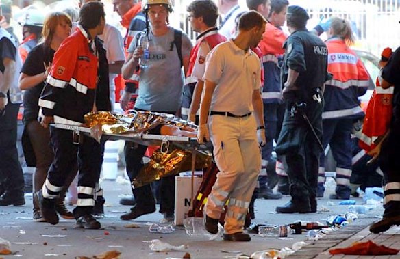 Emergency services personal carry a person on a streacher after panic broke out during the Love Parade in Duisburg, western Germany.