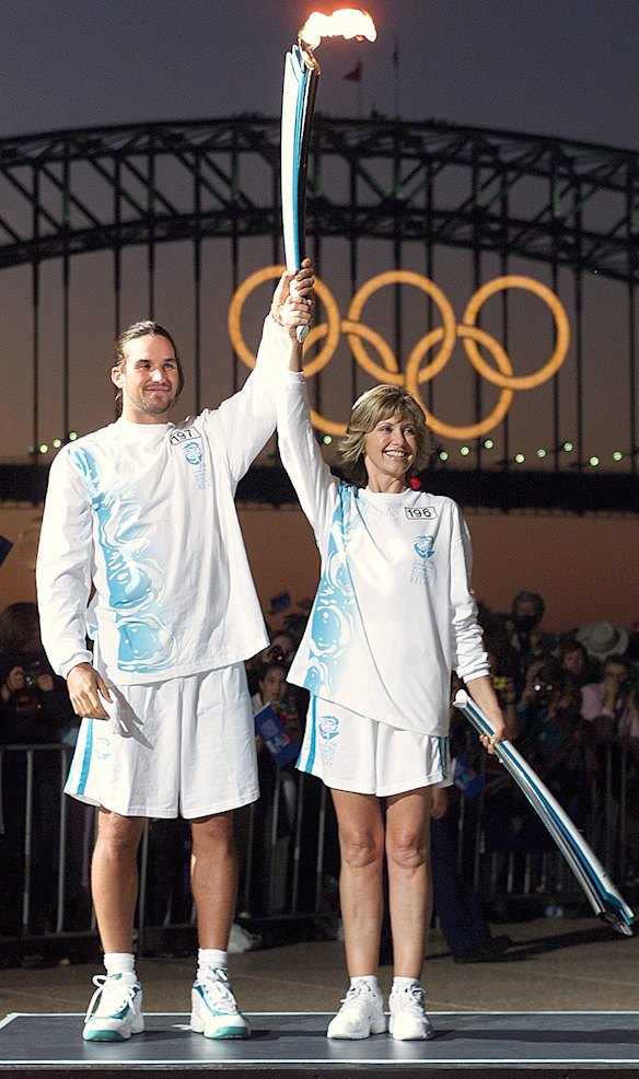 Pat Rafter and Olivia Newton-John at the Sydney Opera House after exchanging the Olympic flame in 2000.  
