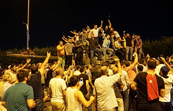 People gather on top of a Turkish army tanks at Ataturk Airport in Istanbul.
