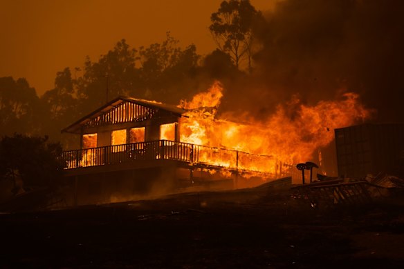 A property in Mogo, a town on the NSW south coast, is engulfed by flames. 