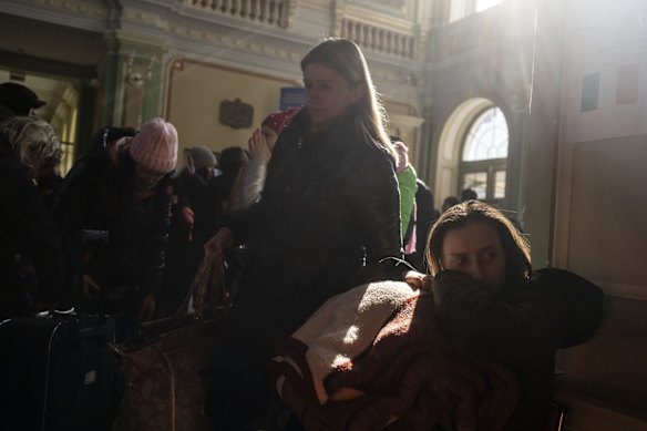 People who fled the war in Ukraine wait at the train station in Przemysl, south-east Poland. Russia's invasion of Ukraine entered its fourth week on Thursday, with Russian forces largely bogged down outside major cities and shelling them from a distance, raining havoc on civilians.