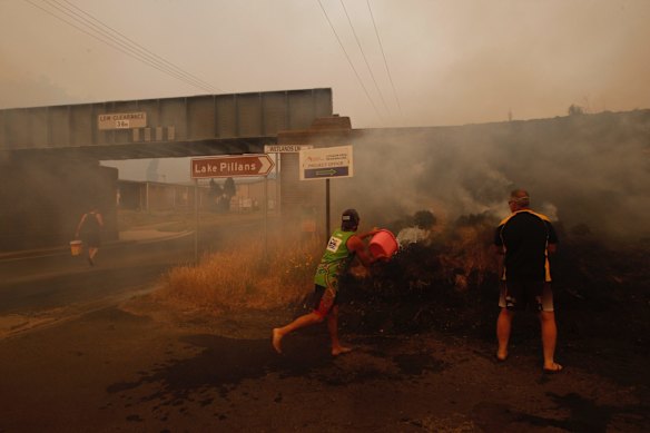 Fire in Lithgow. Locals douse spot fires by the side of the road. 21st December 2019. Photo by Dean Sewell.