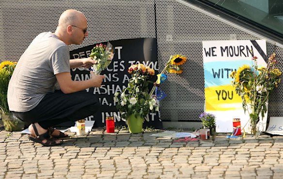 A visitor places flowers at a temporary memorial for the 298 victims of shot down Malaysian jetliner Flight MH17 from Amsterdam to Kuala Lumpur the previous evening, outside of the embassy of the Netherlands, on July 18, 2014 in Berlin, Germany. Malaysia Airlines flight MH17 was travelling from Amsterdam to Kuala Lumpur when it crashed killing all 298 on board including 80 children. The aircraft was allegedly shot down by a missile and investigations continue over the perpetrators of the attack.