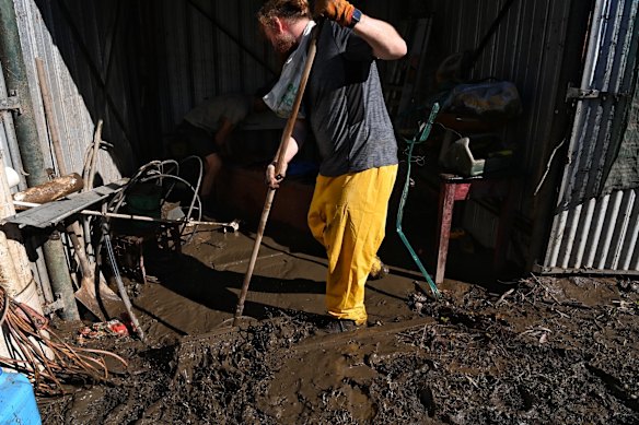 Jon Hall clears mud out of facilities at the Leetsvale Caravan Park on the Hawkesbury River.