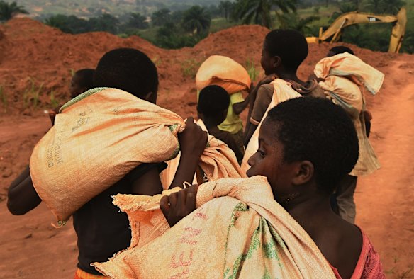 Children carry sacks of soil from the Kabukabuka diamond mine to be washed by men at a waterhole nearby. The children earn 500 Congolese Francs a day for carrying these heavy bags. The conflict in the Kasai has meant that many children cannot attend or afford to go to school. 
