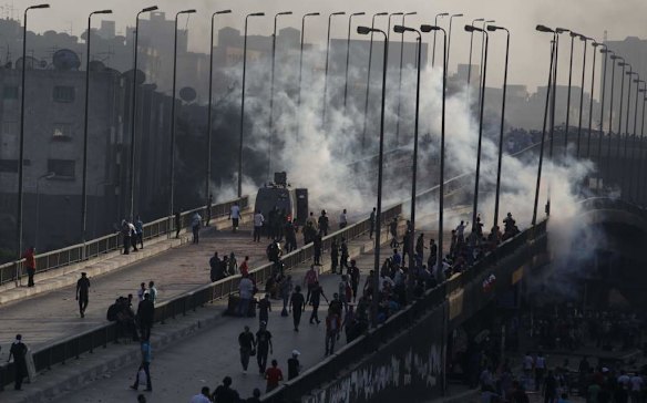 Members of the Muslim Brotherhood and supporters of ousted Egyptian President Mohamed Mursi flee from tear gas and rubber bullets fired by riot police during clashes, on a bridge leading to Rabba el Adwia Square where they are camping, in Cairo.