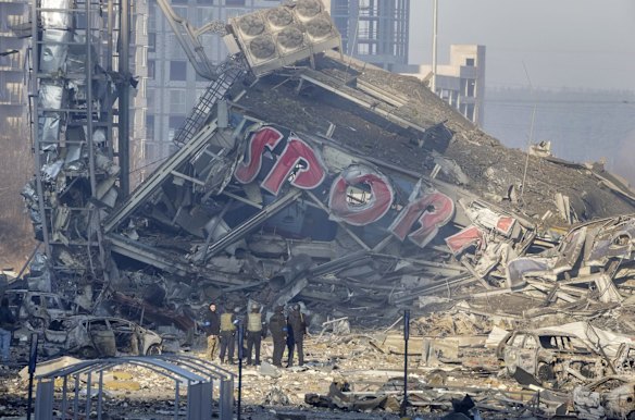 People examine the damage after the bombing of a Kyiv shopping centre.