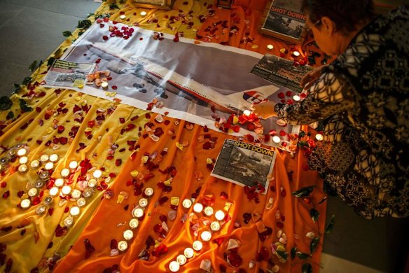 A woman lights candles at a memorial for victims of the downed Malaysia Airlines Flight MH17 in Kuala Lumpur July 18, 2014. The U.S. said on Friday it could not rule out Russian help to separatists in Ukraine in firing an SA-11 surface-to-air missile that likely downed the Malaysian Boeing 777 in eastern Ukraine with 298 people on board.