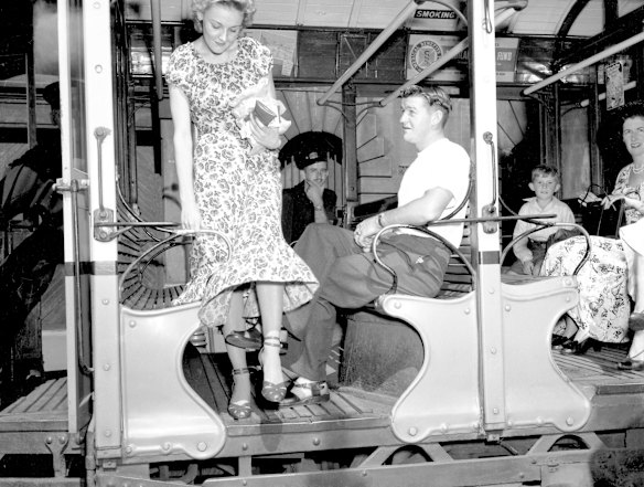 A young lady trips over the legs of fellow passengers in Sydney on 25 January 1950. The image was for a series on "tram manners".
