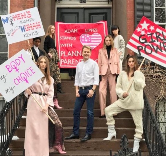 Protest signs for women's reproductive rights and Planned Parenthood lined the stairs outside Adam Lippes' presentation.

