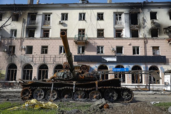 A destroyed tank and a damaged apartment building from heavy fighting are seen in an area controlled by Russian-backed separatist forces in Mariupol.