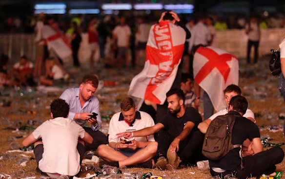 England soccer fans react after losing the semifinal match between Croatia and England at the 2018 soccer World Cup, in Hyde Park, London.