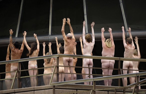 Nude people raise their hands   on the steps of the Sydney Opera House while they pose for a photo by Spencer Tunick.