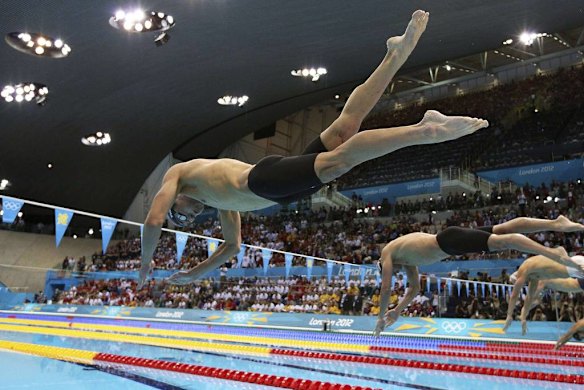 Michael Phelps of the US dives into the pool at the start of the men's 200m individual medley swimming final.