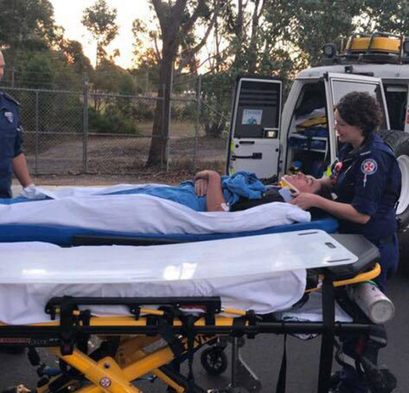 Paramedics attend to Darcy McKay after his bike crashed on a rutted dirt track in Pambula Beach. He used Siri to call triple zero.