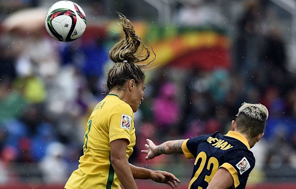 Australia's forward Michelle Heyman (R) and Brazil's defender Monica head the ball.
