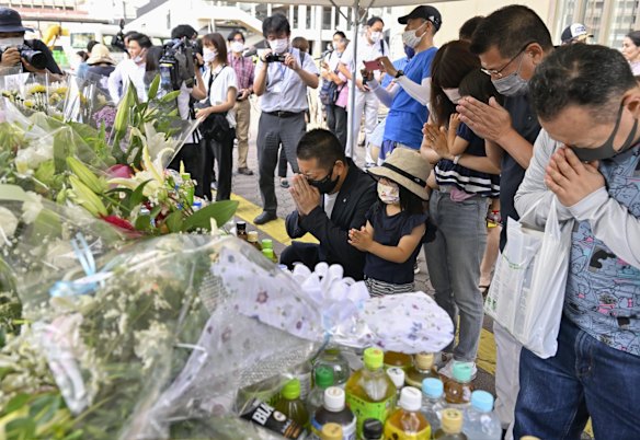 People pray at a makeshift memorial near the scene of the assassination.