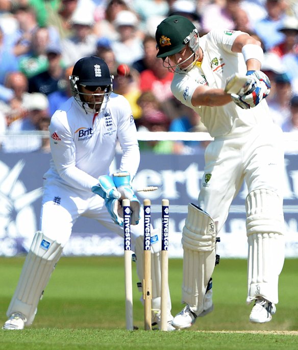 Australia's Brad Haddin (R) is bowled out by England's Graeme Swann (unseen) as England wicketkeeper Matt Prior (L) looks on.