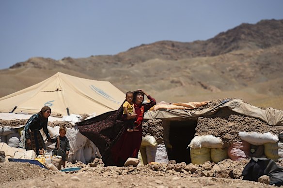 Ziba aged 21 years in front of her family's temporary shelter in Regreshan IDP camp, carrying her son Suleiman aged 1 and a half years old who is suffering from severe acute malnutrition (SAM).