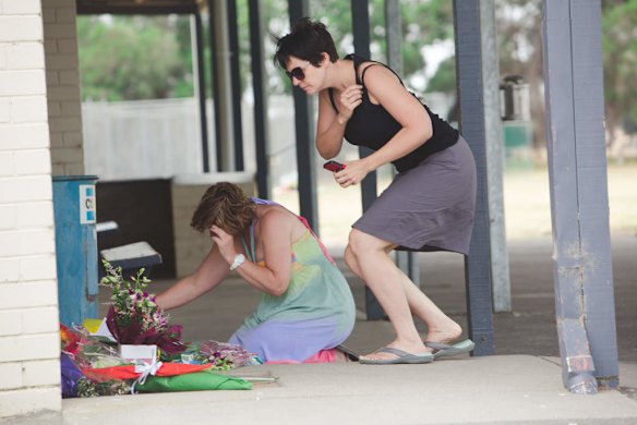 Luke Batty's mother, Rosie Batty (L) and friend back at Tyabb oval today reading cards well wishers have left following the murder of her son here 2 days ago.