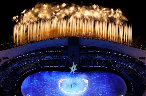 A general view inside the stadium of the Olympic Cauldron as a firework display is seen above.