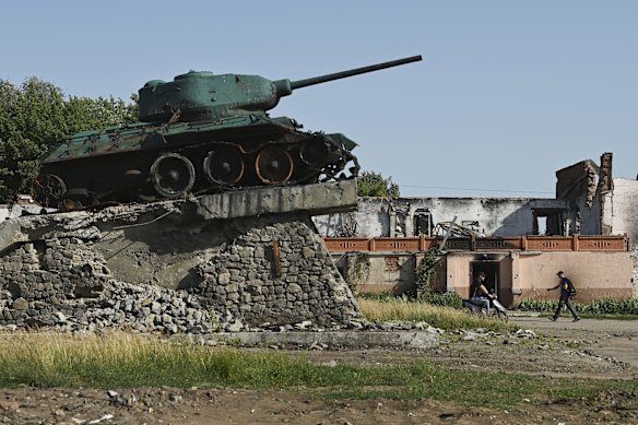 Two men walk past a ruined Soviet tank monument and destroyed and looted buildings in the small town of Trostyanets, north-eastern Ukraine, approximately 30 kilometres from the Russian border. Trostyanets was under Russian occupation for 31 days, and some civilians were detained and tortured. Now the buildings have been shelled, services impacted and roads and cemeteries mined. 