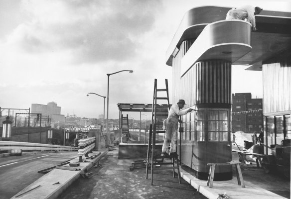 Painters from the Department of Main Roads put finishing touches to one of new toll gates at the northern end of the Harbour Bridge on July 1, 1959.