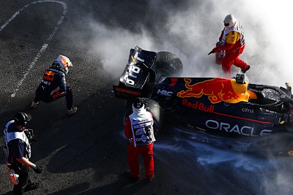Max Verstappen of the Netherlands and Oracle Red Bull Racing and track marshals tend to the fire in his car after he retired from the race.