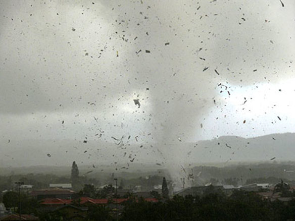 Debris flies as a waterspout sweeps into Lennox Heads.