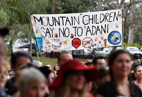 Anti-Adani coal mine protestors are seen rallying at Crosby Park in Brisbane