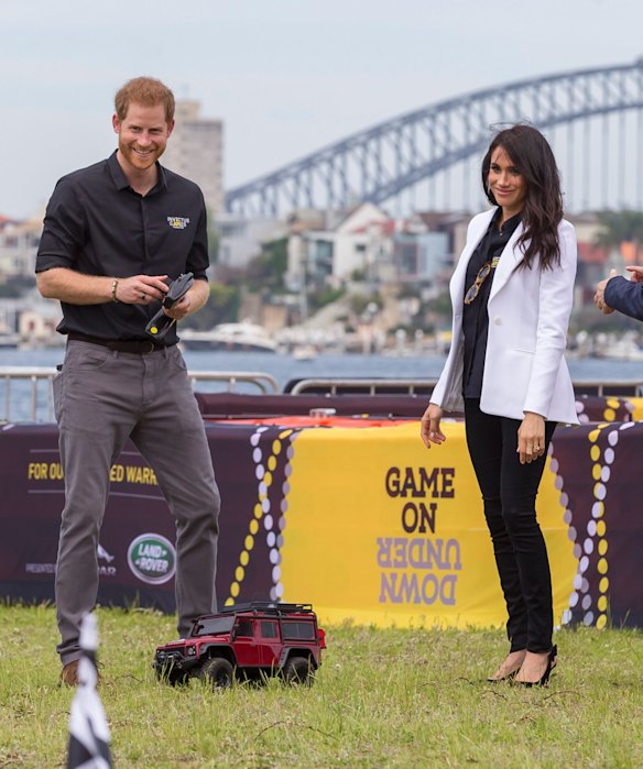 Britain's Prince Harry, the Duke of Sussex and his wife Meghan, the Duchess of Sussex are seen playing with remote control cars during the Jaguar Land Rover Driving Challenge on Day 1 of the Invictus Games on Cockatoo Island in Sydney.