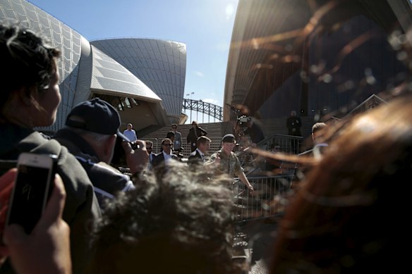 Prince Harry gives thumbs up to a fan as he makes his way into the Opera House after signing autographs and getting the public who have come to wish him farewell. 