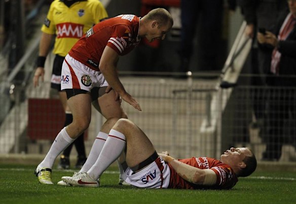 Dragons captain Ben Hornby checks on Beau Scott after he crosses the try line to score.