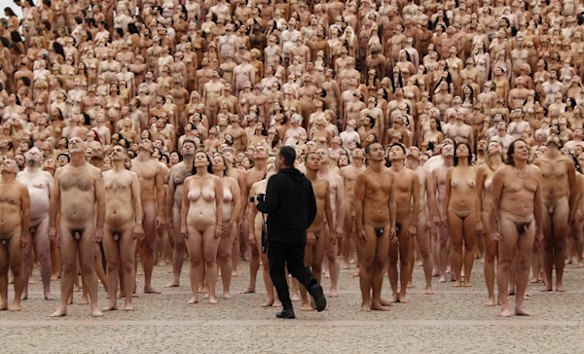 Spencer Tunick walks past naked volunteers as they pose for him in front of the Sydney Opera House.