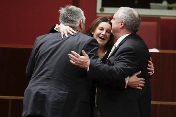 Crossbench senators Rex Patrick, Jacqui Lambie and Stirling Griff celebrate after the passage of the bill.