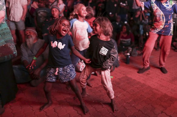 Children dance as they watch bands perform.