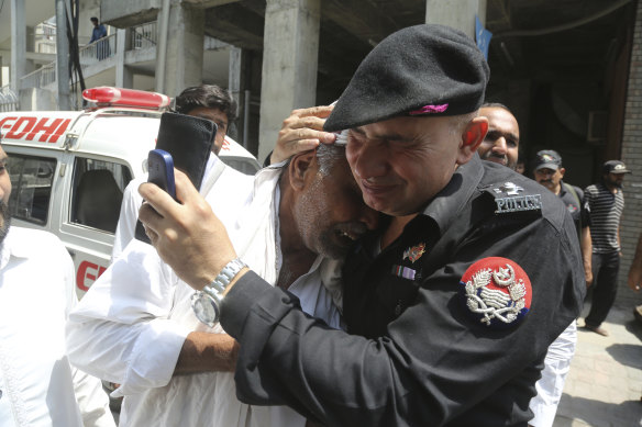 A police officer comforts a man who lost a relative in suicide bomb attack earlier this week. 