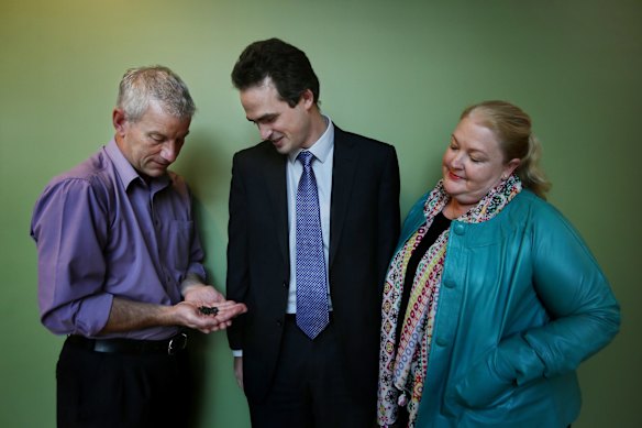 Mark Whattam (left) shows the sunflower seeds to Darryl Barbour (center) and Nicola Hinder (right) all from the Department of Agriculture involved in the importing and growing the sunflowers collected at the MH17 cockpit crash site in East Ukraine, in quarantine and producing healthy seeds.