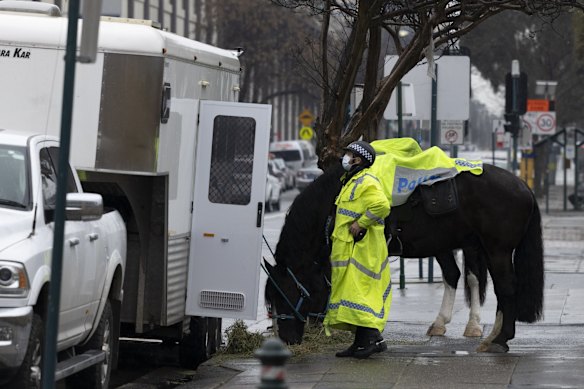 Mounted Police wait for a break in the weather before packing up for the day in Liverpool.