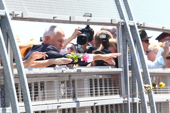 Prime Minister Malcolm Turnbull throws a Rose onto the train tracks.