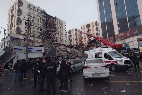 Rescue workers and medical teams try to reach trapped residents in a collapsed building in Diyarbakir, in south-east Turkey.