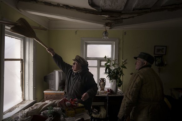 Galina helps clean the house of a neighbor that was damaged by a Russian bombing in Baryshivka, east of Kyiv, Ukraine.