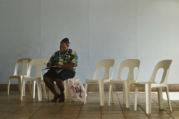 Norah Tabuai, 37, fills out forms as she waits for her second AstraZeneca COVID-19 vaccination on Saibai Island.